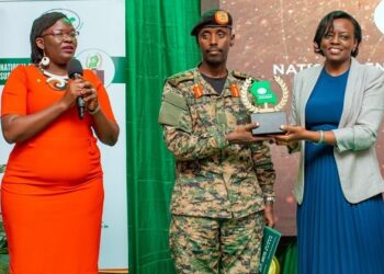 Gen Sabiiti Muzeeyi. General Manager - Luwero Industries Ltd. NEC, handing over the award to Barbara Dokoria (R) the Stanbic Bank Ag. Executive Director, Looking is Diana Ondoga the bank's head of CSI