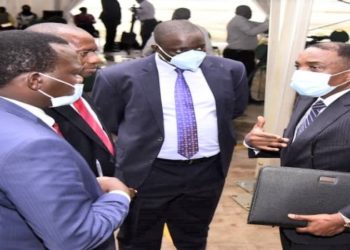 Attorney General William Byaruhanga (R) engaging MPs after a session