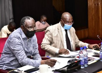 The Chairperson Budget Committee, Hon. Opolot Patrick Isiagi (left), interacting with the team from KCCA.