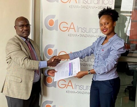 Gordon Asimwe, Marketing Manager GA, Insurance handin over the travel documents to Emily Mahero, the Mayhem Winner at GA Offices.