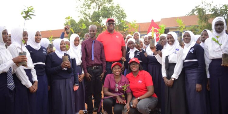 Mumba Kalifungwa, Absa Bank Uganda’s Managing Director (up in a red cap) poses for a photo with students of Highland Secondary School in Kisaasi on Tuesday. Photo@mumbaKalifungwa