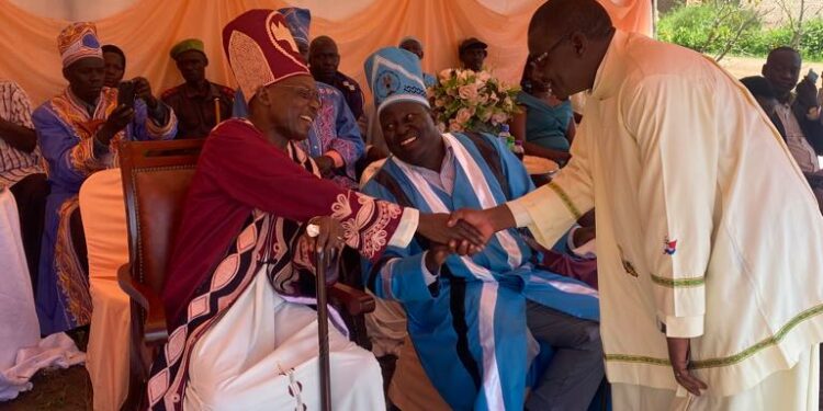 Catechist Jasper Onume greets Paramount Chief Eng Dr Michael Moses Odongo-Okune during the installation ceremony of Santo Angodo as the clan chief(awitong)of Bakocol in Lira City.