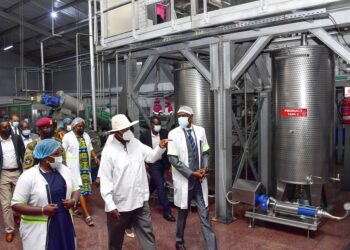 Francis Mugabe (2nd R), proprietor of Kike Tropical Fruit factory in Kakooge, Nakasongola and his team take President Museveni on a guided tour of the factory shortly after its commissioning on Thursday. PPU