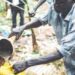 A man filling a jerrycan with tonto