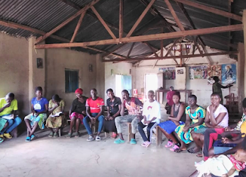 coordinator Compassion connectors in Western Uganda speaking during the community outreach aimed at extending hands-on skills education training in Kyegegwa village.