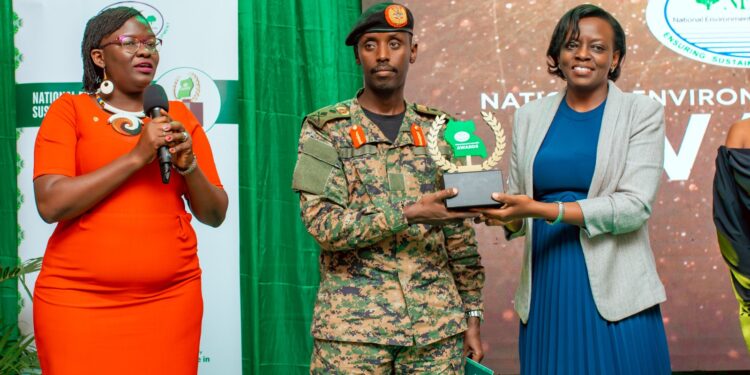 Maj. Gen Sabiiti Muzeeyi. General Manager - Luwero Industries Ltd. NEC, handing over the award to Barbara Dokoria (R) the Stanbic Bank Ag. Executive Director, Looking is Diana Ondoga the bank's head of CS