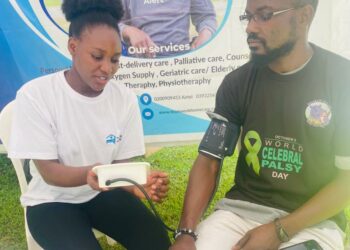 A Nurse in white t-shirt attached to Teamwork Homecare Services takes a Blood Pressure reading of a guest at a recent medical outreach. The firm specialises in management of chronic diseases like Hypertension and the provision of office, home based and emergency medical care to patients