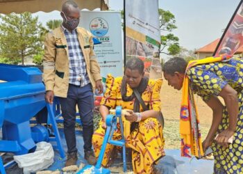 Women trying out NAROs hand maize sheller during the event held at Bukwiri C.O.U Primary School under the theme “Accelerate Action for Gender Equality,” the event highlighted NARO’s efforts to ease farm labor, boost productivity, and lift incomes through gender-responsive technologies.